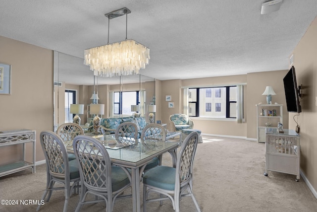 dining space featuring an inviting chandelier, carpet, baseboards, and a textured ceiling