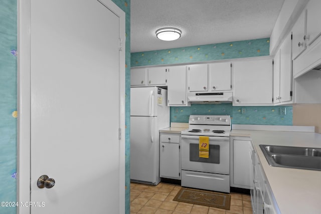 kitchen with white appliances, white cabinets, light countertops, a textured ceiling, and under cabinet range hood