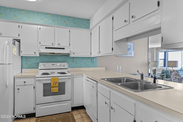 kitchen with under cabinet range hood, white appliances, a sink, and light countertops