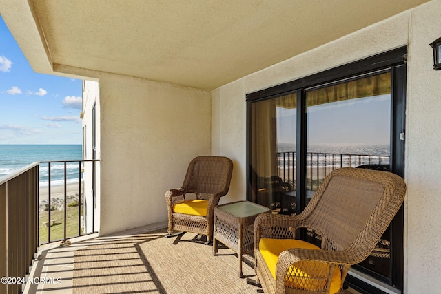 balcony with a water view and a beach view