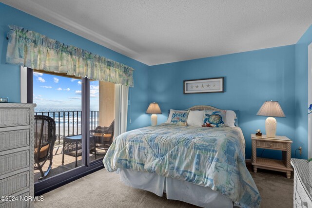 bedroom with access to exterior, carpet, and a textured ceiling