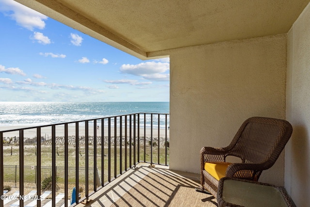 balcony with a water view and a beach view