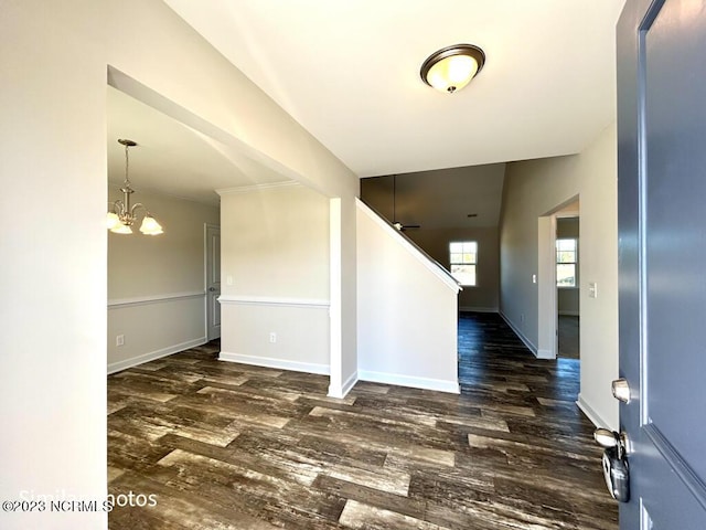 foyer with an inviting chandelier, wood finished floors, and baseboards