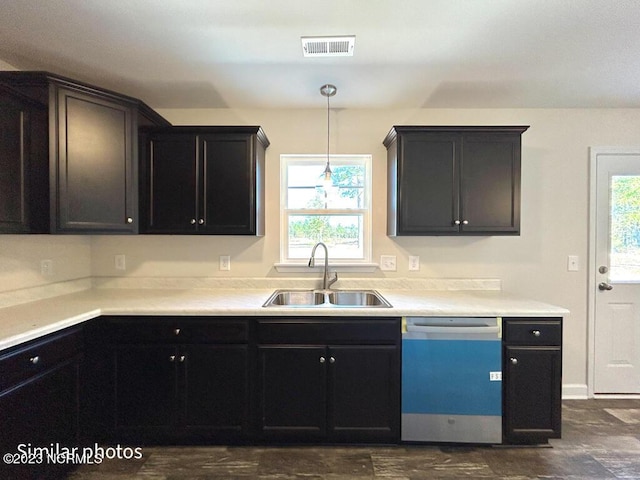 kitchen with dishwashing machine, a sink, visible vents, light countertops, and pendant lighting