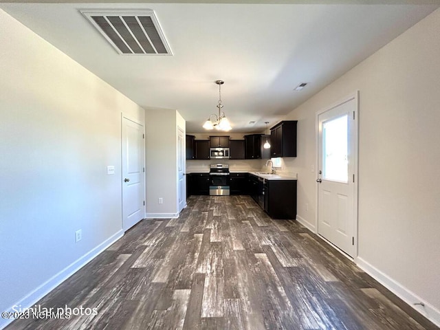 kitchen featuring baseboards, visible vents, dark wood-type flooring, stainless steel appliances, and light countertops