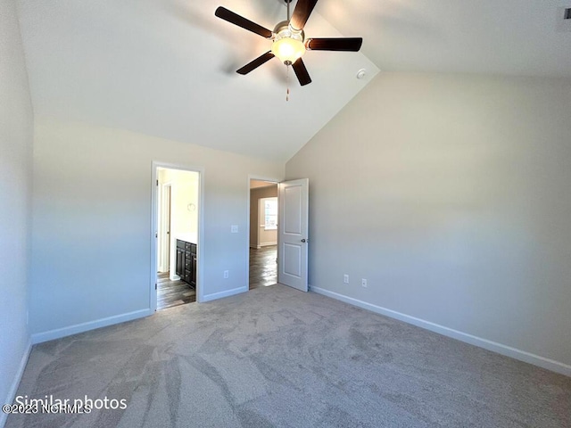 unfurnished bedroom featuring baseboards, a ceiling fan, ensuite bath, carpet flooring, and high vaulted ceiling