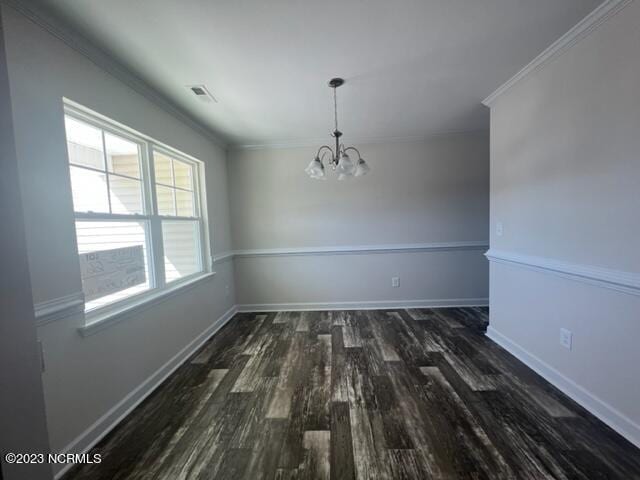 unfurnished dining area featuring baseboards, a notable chandelier, ornamental molding, and wood finished floors