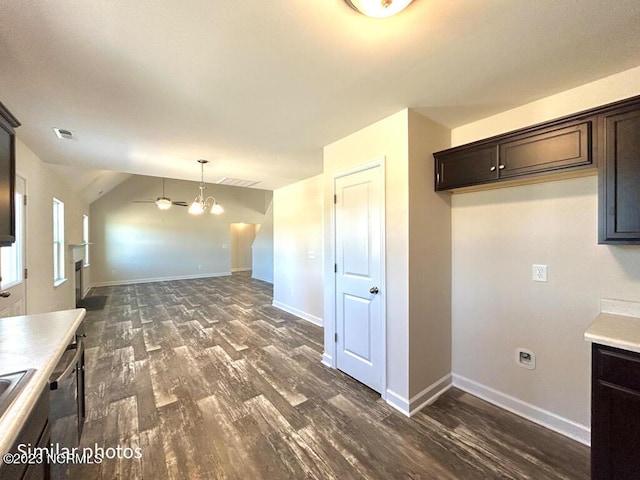 kitchen featuring visible vents, stainless steel dishwasher, dark wood-type flooring, vaulted ceiling, and dark brown cabinets