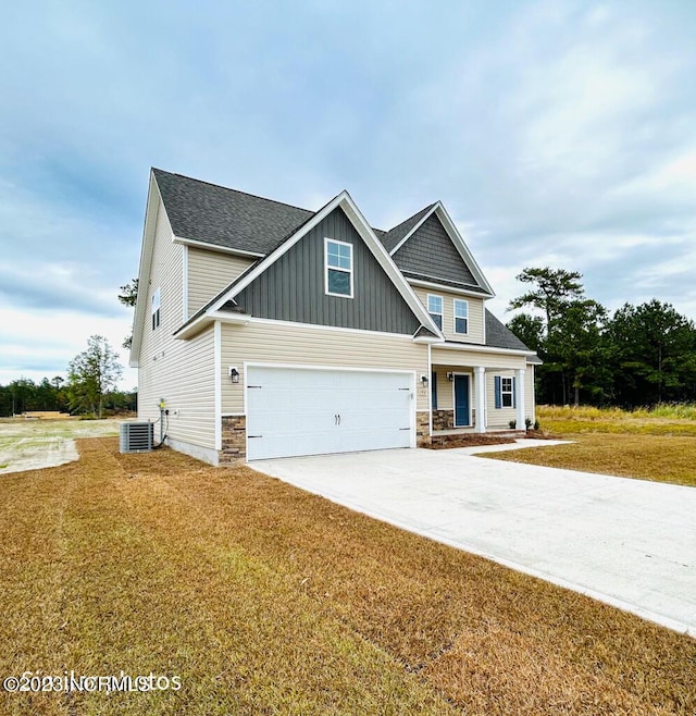 craftsman-style home featuring driveway, a garage, stone siding, a front lawn, and board and batten siding