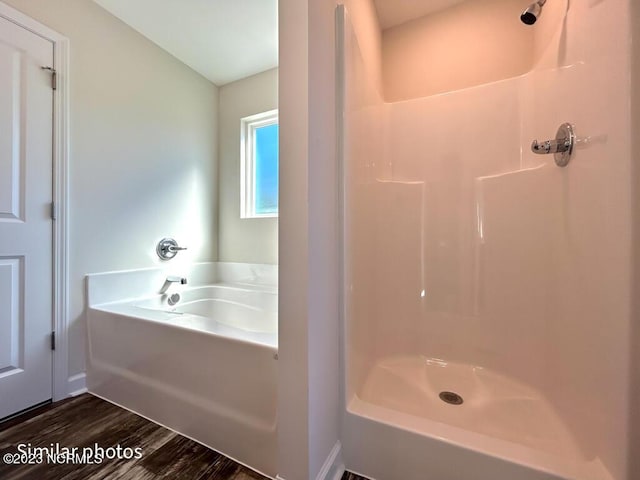 full bathroom featuring a garden tub, a shower, and wood finished floors