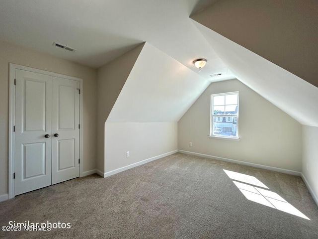 bonus room featuring lofted ceiling, carpet, visible vents, and baseboards