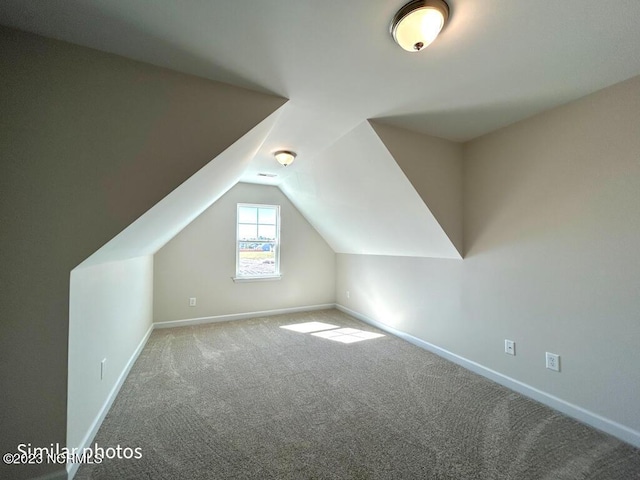 additional living space featuring carpet floors, baseboards, and vaulted ceiling