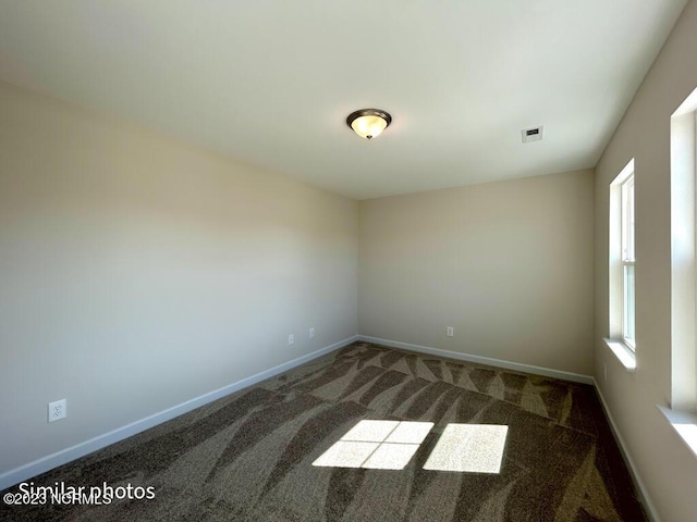 carpeted spare room featuring visible vents and baseboards