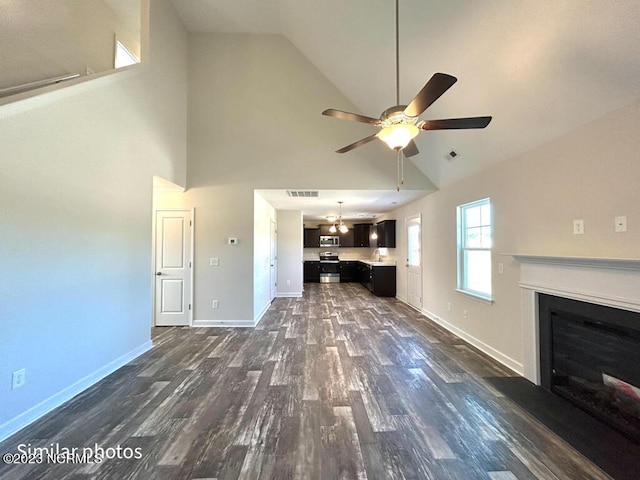 unfurnished living room featuring visible vents, baseboards, ceiling fan, dark wood-style flooring, and a fireplace