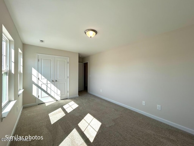 interior space with carpet floors, visible vents, and baseboards