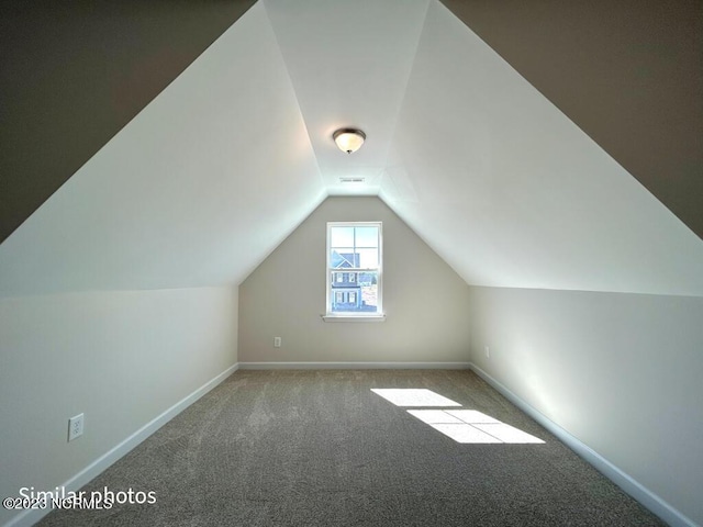 bonus room featuring lofted ceiling, carpet, and baseboards