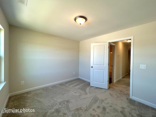 unfurnished bedroom with carpet floors, visible vents, and baseboards