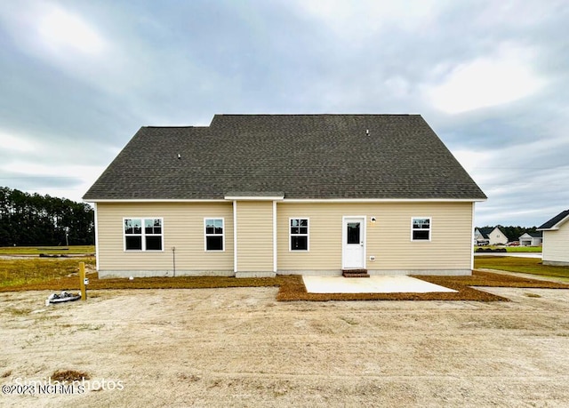 back of property featuring a patio area and a shingled roof