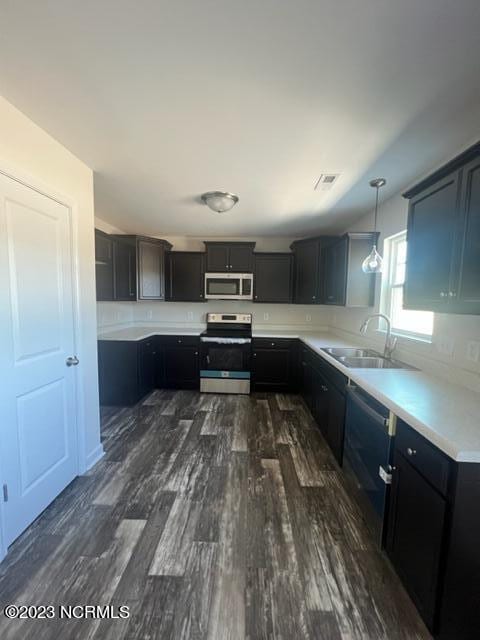 kitchen with visible vents, appliances with stainless steel finishes, dark wood-style flooring, light countertops, and a sink