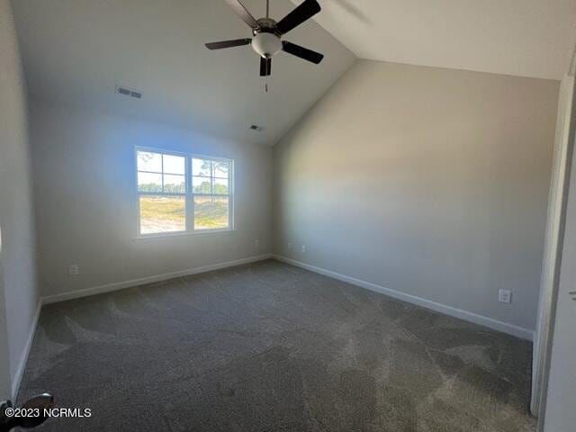 carpeted spare room with a ceiling fan, lofted ceiling, visible vents, and baseboards