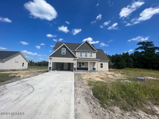 view of front of house with an attached garage, covered porch, and concrete driveway