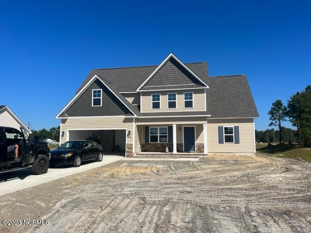 craftsman-style house with driveway, covered porch, a garage, and stone siding