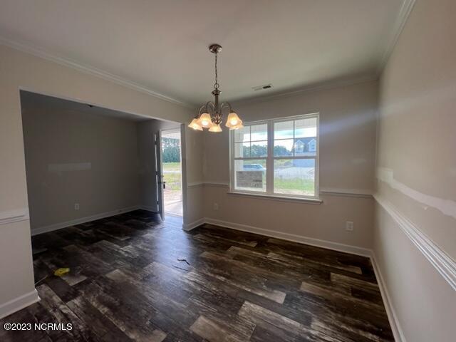 unfurnished dining area with ornamental molding, wood finished floors, and baseboards