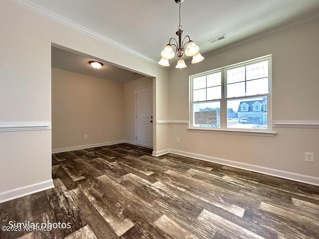 spare room with baseboards, visible vents, crown molding, and wood finished floors