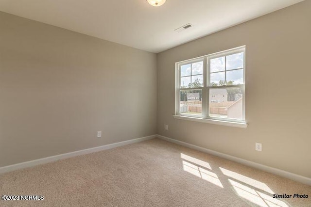 unfurnished room featuring baseboards, visible vents, and carpet flooring