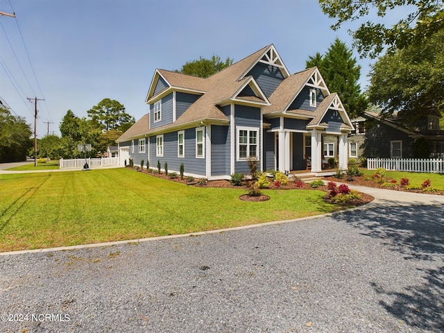 view of front of home with driveway, fence, and a front yard