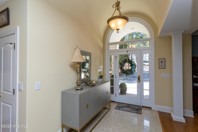 foyer featuring ornate columns and baseboards