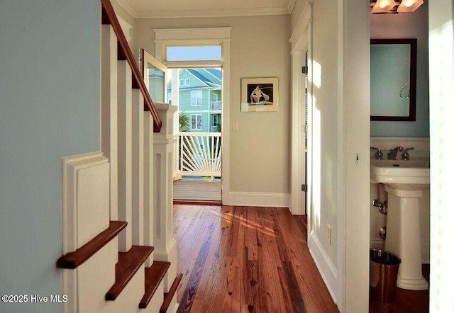 hall with stairs, ornamental molding, baseboards, and wood finished floors