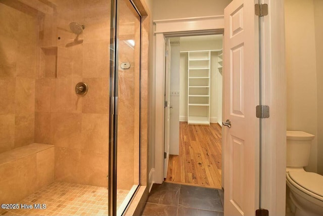 full bathroom with a stall shower and toilet