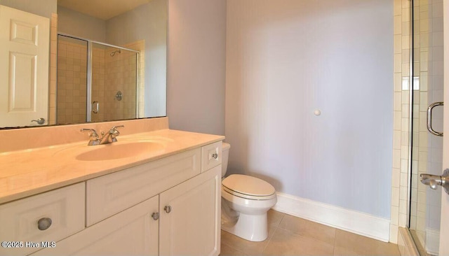 bathroom featuring toilet, vanity, a shower stall, baseboards, and tile patterned floors