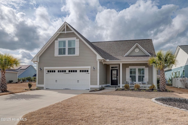 view of front of home with a garage, a porch, concrete driveway, and roof with shingles