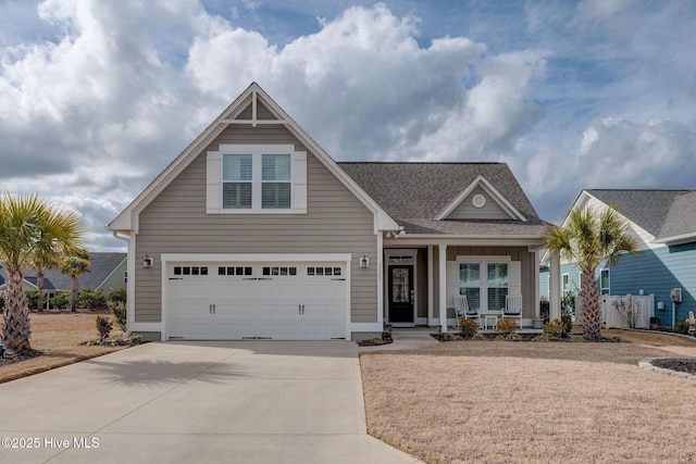 view of front of house featuring driveway, a porch, roof with shingles, and an attached garage