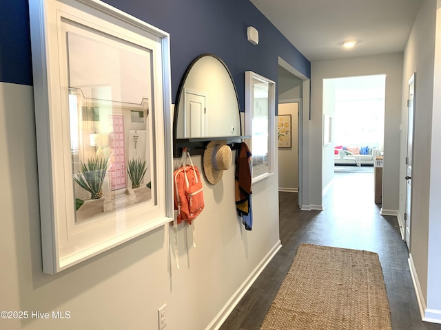 hallway featuring dark wood finished floors and baseboards