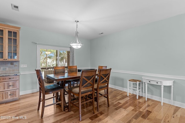 dining area featuring baseboards, visible vents, and light wood-style floors