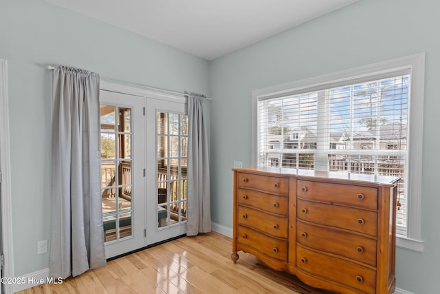 doorway with light wood finished floors and baseboards