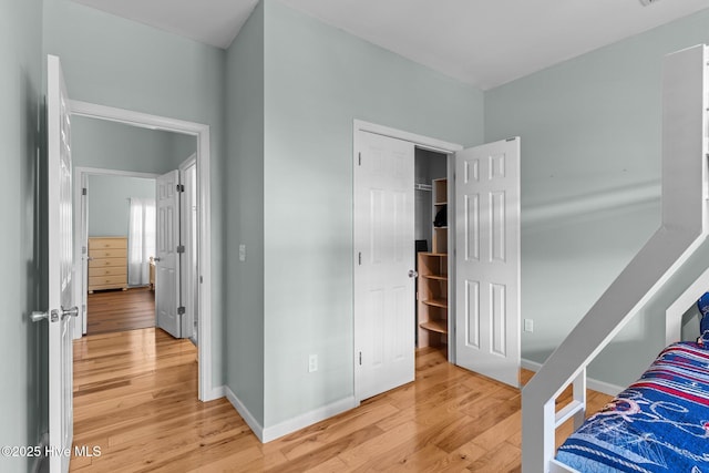 bedroom with light wood finished floors and baseboards