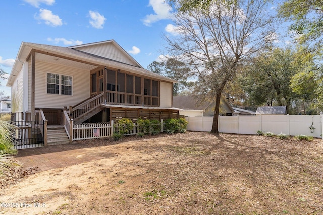 back of property featuring a sunroom, fence, and stairs