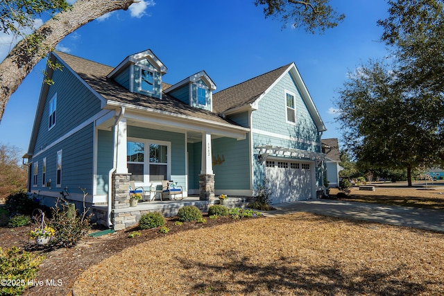 view of front facade featuring a garage, driveway, a porch, and roof with shingles