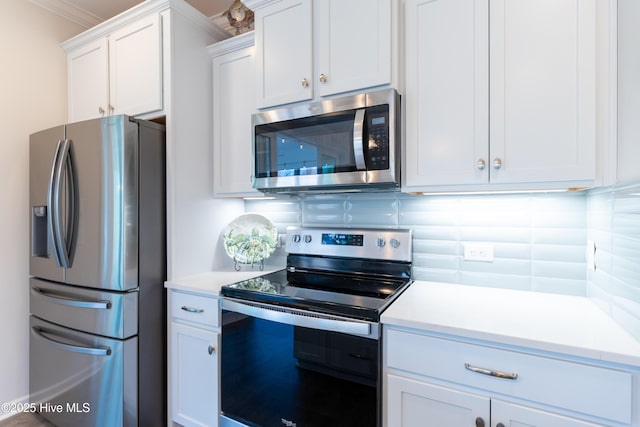 kitchen featuring stainless steel appliances, white cabinetry, tasteful backsplash, and light countertops