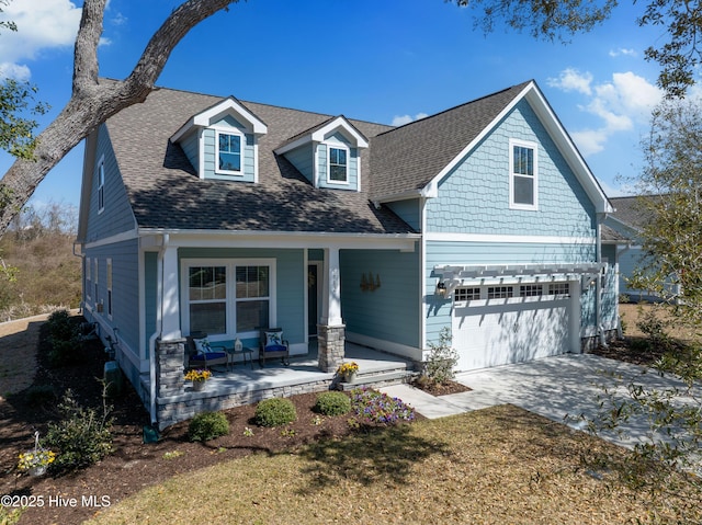 craftsman house featuring an attached garage, a porch, concrete driveway, and roof with shingles