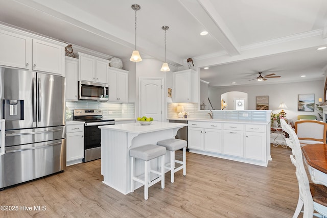 kitchen with beamed ceiling, appliances with stainless steel finishes, a peninsula, light countertops, and ceiling fan