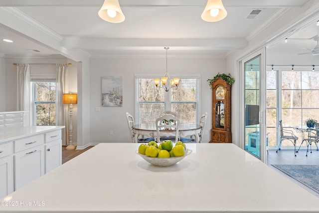 dining area featuring visible vents, plenty of natural light, an inviting chandelier, and ornamental molding