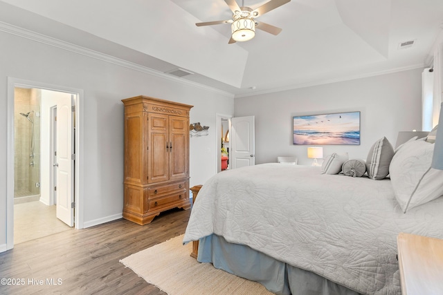 bedroom featuring a raised ceiling, visible vents, light wood finished floors, and ornamental molding