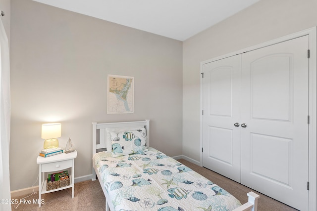 bedroom featuring a closet, baseboards, and carpet flooring