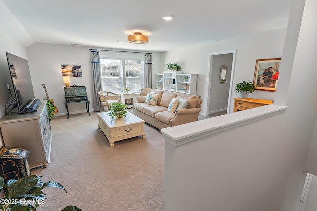 living area featuring baseboards, light colored carpet, and vaulted ceiling