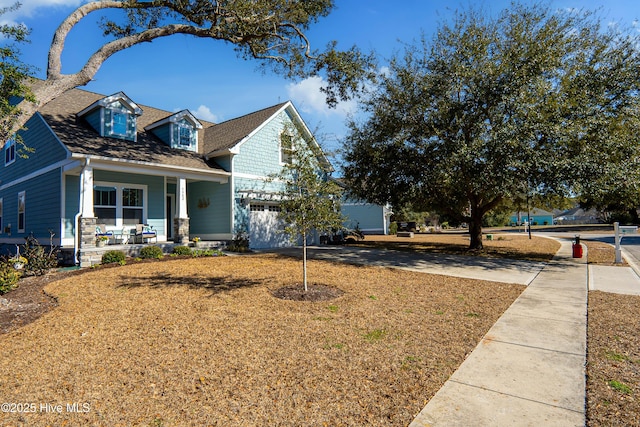 view of front of property featuring roof with shingles, a porch, and concrete driveway